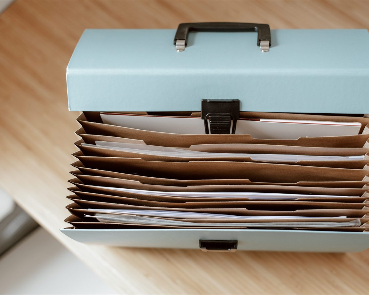 Arquivo com documentos organizados em divisórias sobre uma mesa